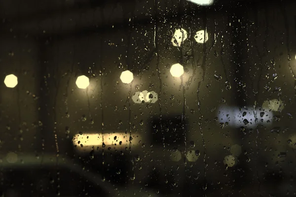 Rain drops on window with street bokeh lights — Stock Photo, Image