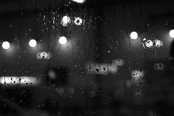 Chuva cai na janela com luzes bokeh rua — Fotografia de Stock