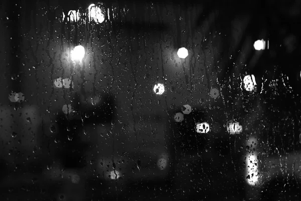 Regentropfen auf Fenster mit Straßenlaternen — Stockfoto