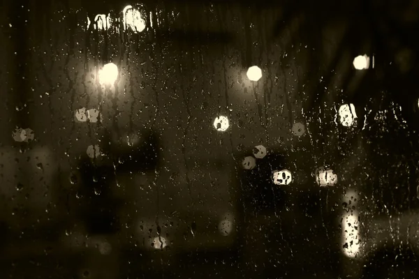 Rain drops on window with street bokeh lights — Stock Photo, Image