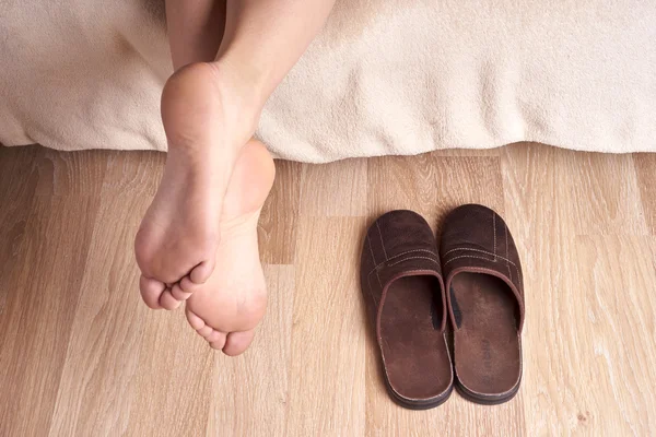 Pies femeninos y zapatillas — Foto de Stock