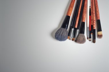 Makyaj fırçası ve kozmetik, renkli arka plan üzerinde