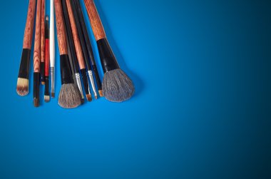 Makyaj fırçası ve kozmetik, renkli arka plan üzerinde