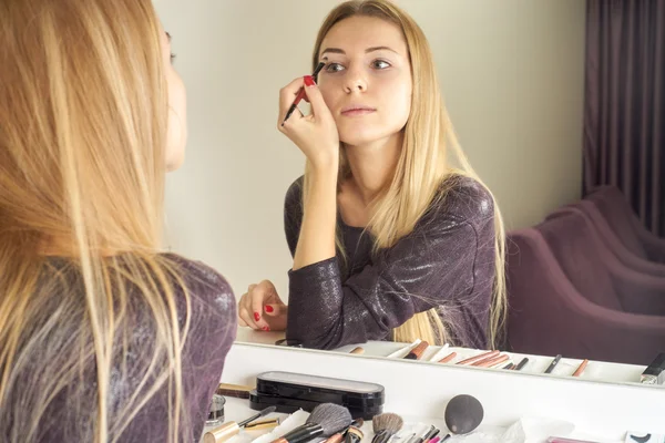 Отклонение молодой красивой женщины, наносящей свой макияж — стоковое фото