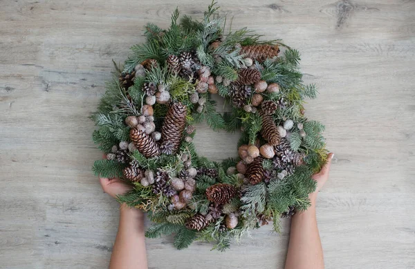 Frau Hält Weihnachtskranz Auf Hellem Holzgrund Grüner Naturkranz Mit Nüssen — Stockfoto