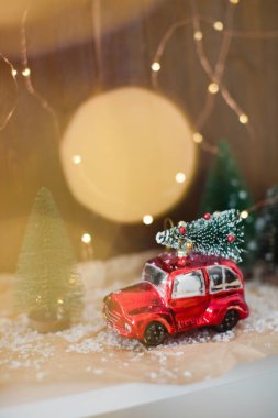 Noel ağacı olan küçük kırmızı bir araba. Noel konsepti, tatil teslimatı. Noel süslemeleri ve Noel ışıkları
