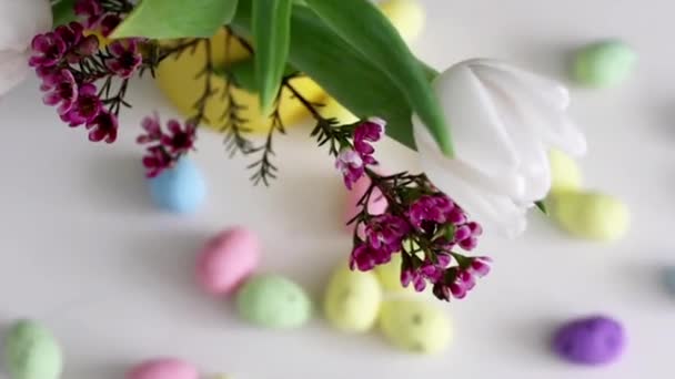 ヴィンテージメタルバスケットのカラフルなイースターエッグと白い背景の花 — ストック動画