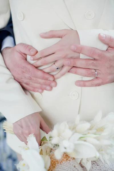 Nevěsta Béžovém Svatebním Obleku Drží Ruce Ženichem Tmavomodrém Obleku Stylový — Stock fotografie