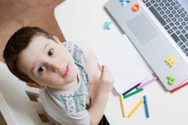 Çevrimiçi eğitim konsepti. Kafkasyalı küçük çocuğun bilgisayarında video çalışması var, evde eğitim kavramı. Anaokulu çevrimiçi çalışması