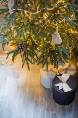 Noel ağacının yanında kurdeleli hediye kutuları. Noel sabahı, süslemeleri ve ışıkları olan Noel ağacı
