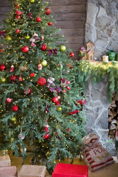 빨간색으로 장식된 크리스마스 트리와 크리스마스 복장으로 장식된 벽난로 — 스톡 사진