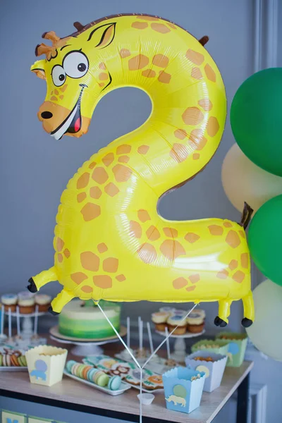 Jungle party animal balloons decorations. Child's birthday party with colorful balloons near grey wall