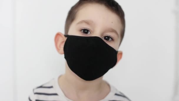 白地にカメラを見て黒い顔のマスクで白人少年 コピースペース テキストのための場所 — ストック動画