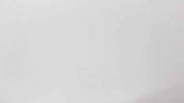 Beyaz tenli, kısa doğal tırnaklı bir kadının sağ elinin yakın çekimi çerçevenin alt kısmından giriyor ve fildişinin manşetine atıfta bulunarak bir dizi Arjantin pesosu sunuyor.