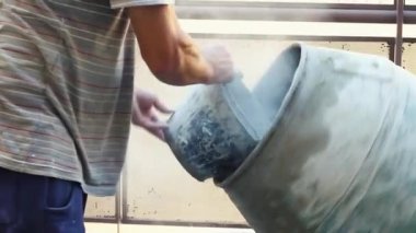 Kolların ve orta gövdenin bir kısmı tuğlacının bir kova dolusu çimentoyu karıştırma makinesine dökerek çerçevenin solundan sağa doğru çimento oluşturur.