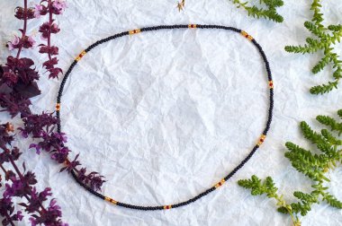 El yapımı boncuk, hobi olarak boncuklama. Çeşitli çiçek ve bitkilerin arka planında kendi ellerinizle yapılmış süslemeler..