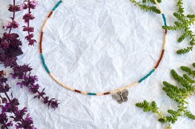 El yapımı boncuk, hobi olarak boncuklama. Çeşitli çiçek ve bitkilerin arka planında kendi ellerinizle yapılmış süslemeler..