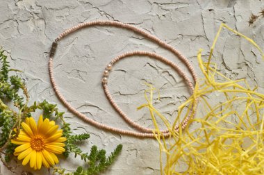 El yapımı boncuk, hobi olarak boncuklama. Çeşitli çiçek ve bitkilerin arka planında kendi ellerinizle yapılmış süslemeler..