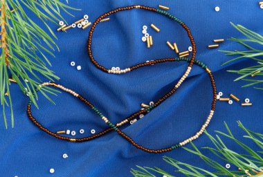 El yapımı boncuk, hobi olarak boncuklama. Çeşitli çiçek ve bitkilerin arka planında kendi ellerinizle yapılmış süslemeler..