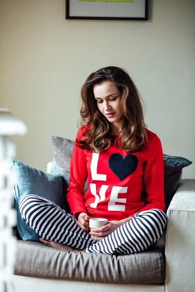 Mujer joven relajándose en pijama — Foto de Stock