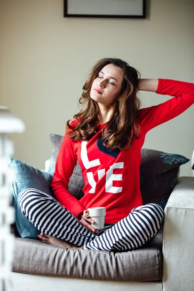 Mujer joven relajándose en pijama — Foto de Stock