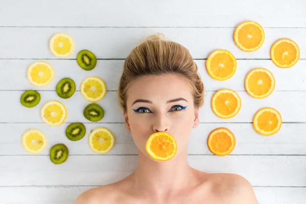旁边的橙、 柠檬、 猕猴桃片铺设的金发女人 — 图库照片