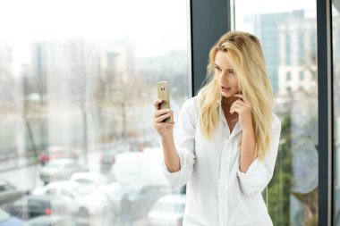 Bir pencere yanında güzel sarışın kadın