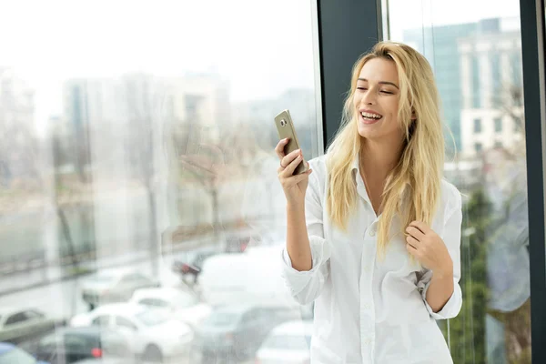 Hermosa mujer rubia al lado de una ventana — Foto de Stock