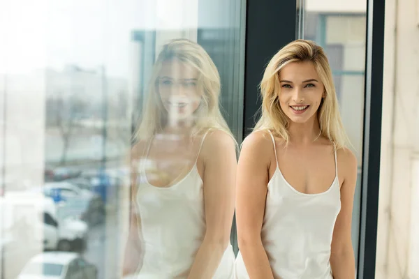 Mooie blonde vrouw naast een venster — Stockfoto