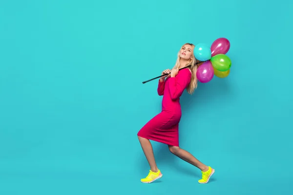 Blonde woman with balloons on blue — Stock Photo, Image