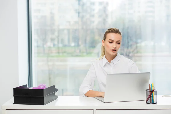 Blonde woman behind her desk — Stock Photo, Image
