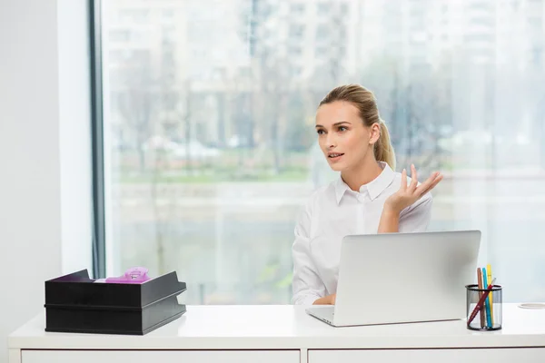 Blonde Frau hinter ihrem Schreibtisch — Stockfoto