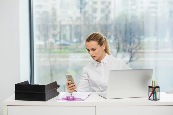 Blonde woman behind her desk — Stock Photo, Image