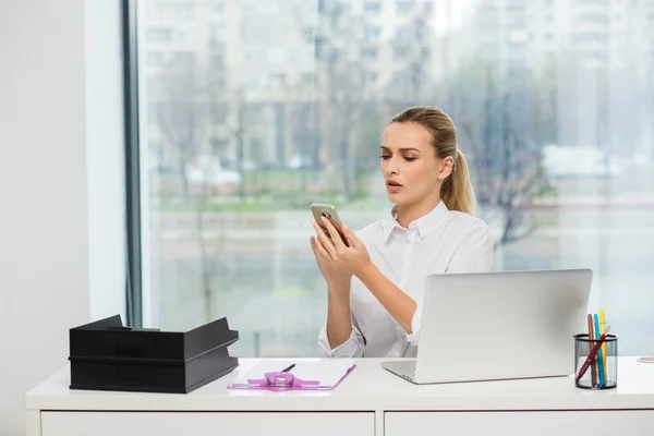 Blonde woman behind her desk — Stock Photo, Image