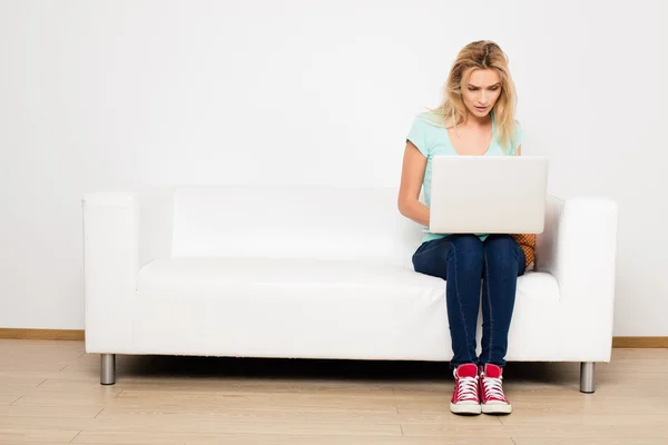 Blonde Frauen auf Couch mit Kopfkissen — Stockfoto