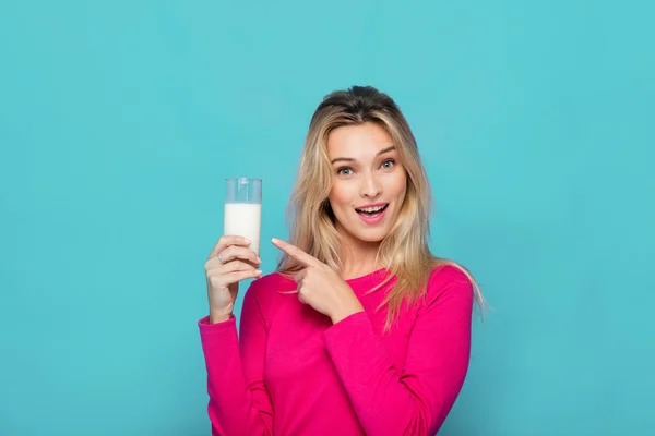 Mujer joven rubia un vaso de leche en azul — Foto de Stock