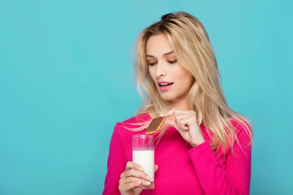 Mujer joven rubia un vaso de leche en azul — Foto de Stock