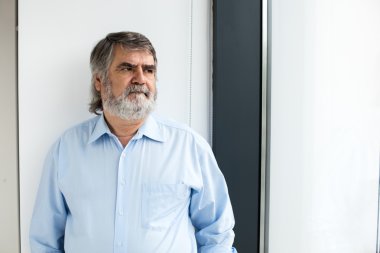 bir pencere yanında duran öğretmen