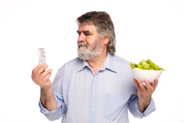 yaşlı adam hapları ve salata ile