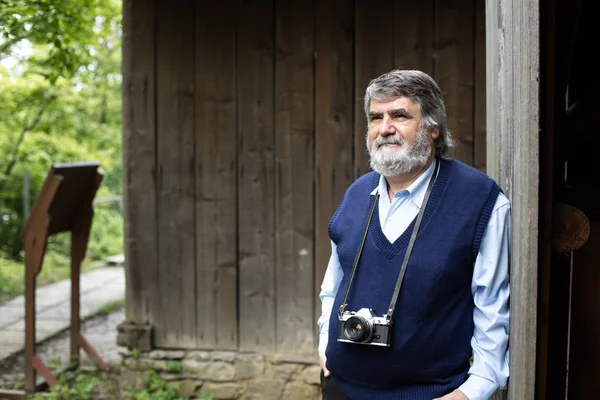 Oude fotograaf permanent op houten achtergrond — Stockfoto