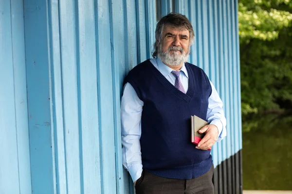 Oude man met een boek op een veranda — Stockfoto