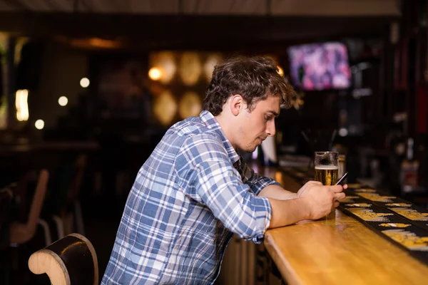 Hombre soltero sentado en el bar tomando una cerveza — Foto de Stock