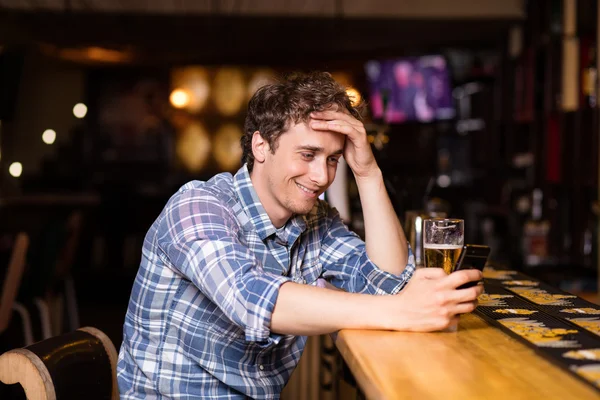 Single man sitting at bar having a beer — Stock Photo, Image