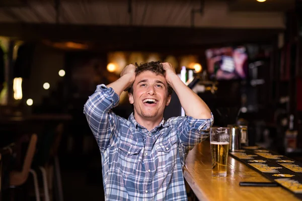 Single man sitting at bar having a beer — Stock Photo, Image