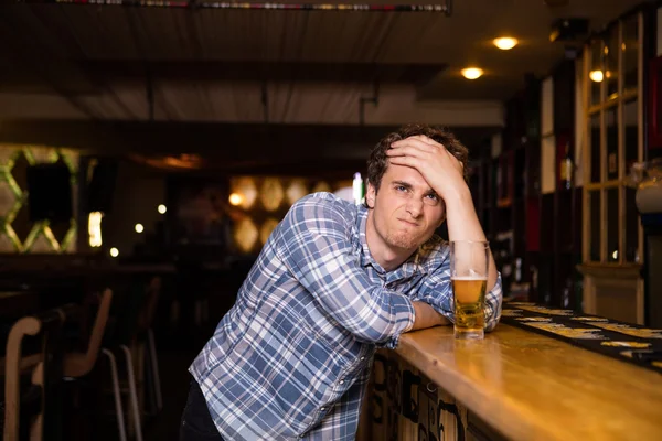 Hombre soltero sentado en el bar tomando una cerveza —  Fotos de Stock