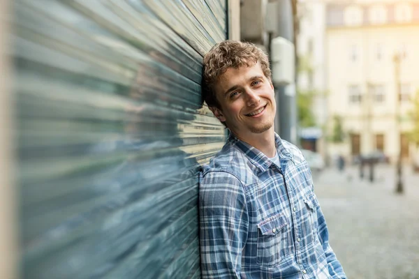 Jonge man in een geruit overhemd reputatie buiten — Stockfoto