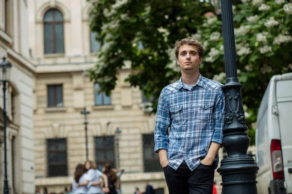 Giovane uomo in camicia a scacchi in piedi fuori — Foto Stock