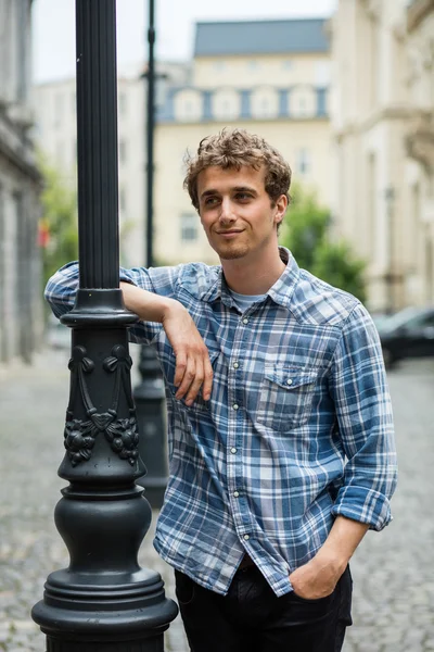 Jovem homem de camisa quadriculada em pé fora — Fotografia de Stock