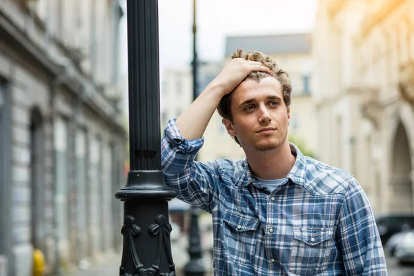 Junger Mann im karierten Hemd steht draußen — Stockfoto