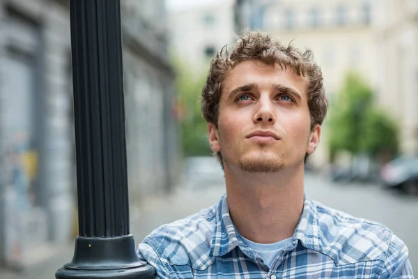 Young man in checkered shirt standing outside — Stock Photo, Image